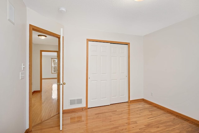 15767 Porchlight Ln, Eden Prairie, MN 55347 - unfurnished bedroom featuring baseboards, visible vents, a closet, and light wood-type flooring