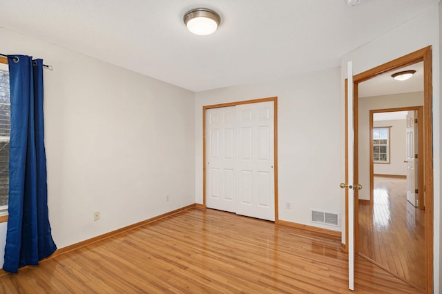 15767 Porchlight Ln, Eden Prairie, MN 55347 - unfurnished bedroom with baseboards, visible vents, a closet, and light wood finished floors