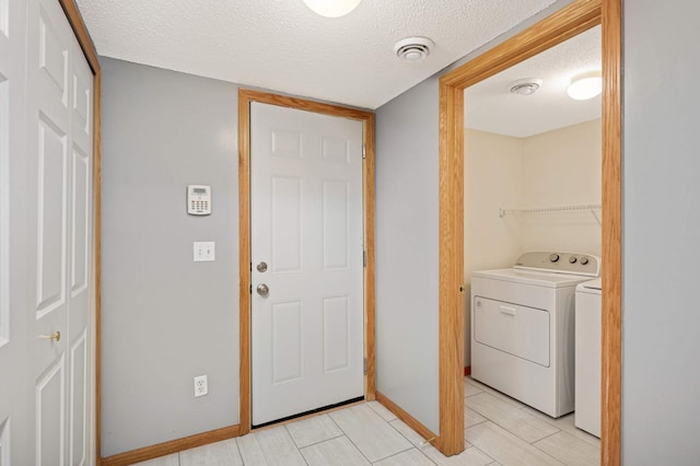 15767 Porchlight Ln, Eden Prairie, MN 55347 - clothes washing area with baseboards, washer and clothes dryer, laundry area, and a textured ceiling