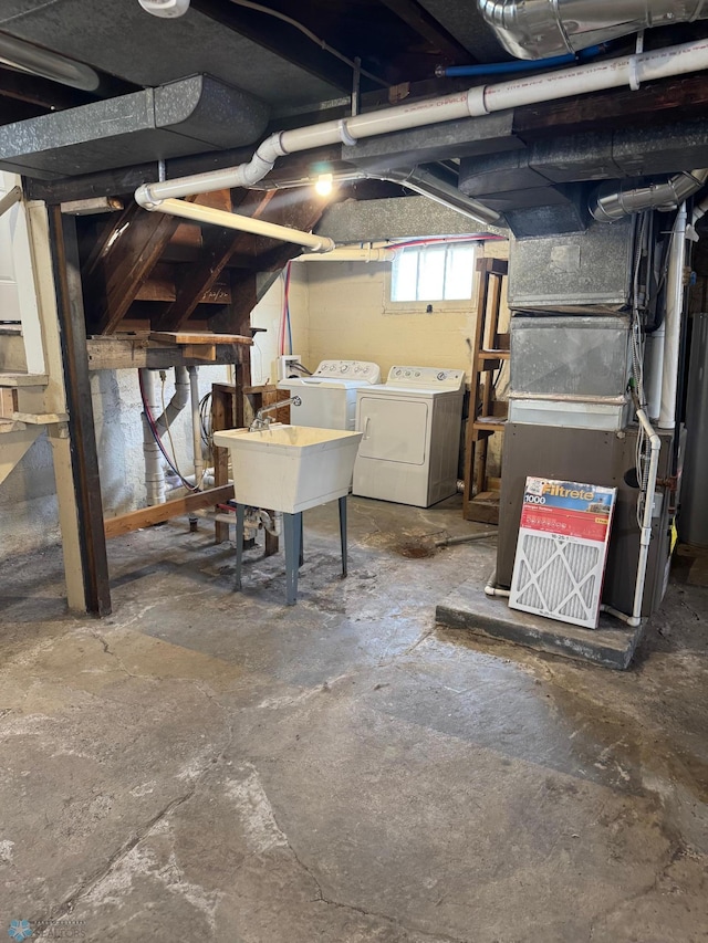 below grade area featuring separate washer and dryer, heating unit, and a sink