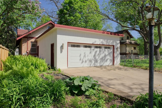 garage with fence and driveway
