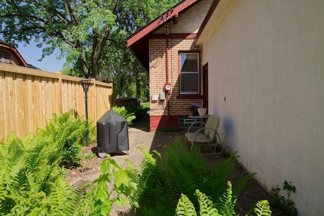 view of side of property with fence and brick siding