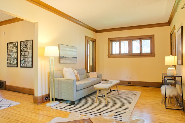 living area with light wood-style flooring, crown molding, and baseboards