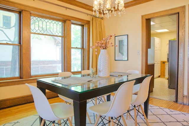 dining room with light wood-type flooring and a chandelier