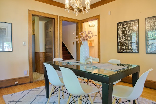 dining area with a chandelier, stairs, light wood finished floors, and baseboards