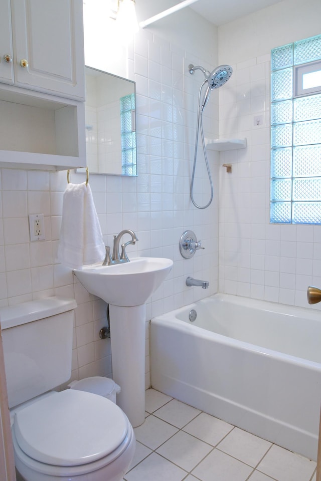 bathroom featuring tile walls, tile patterned floors, toilet, and shower / washtub combination