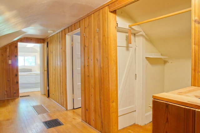 bonus room with vaulted ceiling and light wood-style floors
