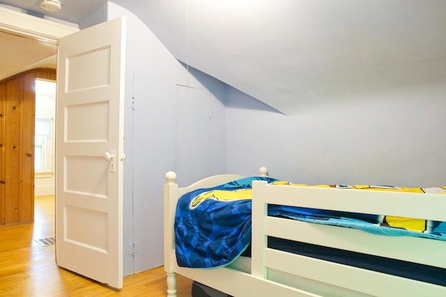 bedroom with light wood-style flooring and lofted ceiling