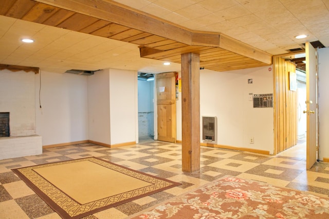 finished basement featuring heating unit, baseboards, tile patterned floors, recessed lighting, and a fireplace
