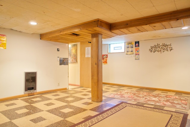 below grade area featuring baseboards, heating unit, and recessed lighting