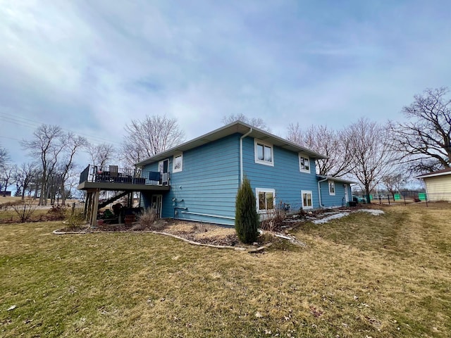 view of side of home with stairs, a deck, and a yard