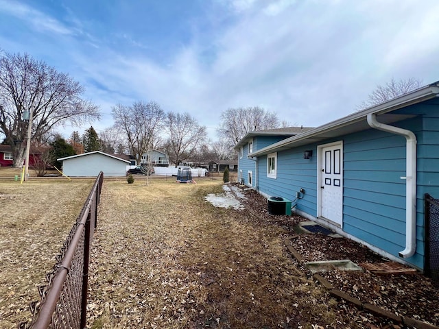view of yard featuring central air condition unit and fence