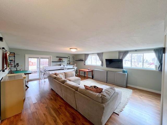living room featuring hardwood / wood-style flooring, baseboards, and a textured ceiling