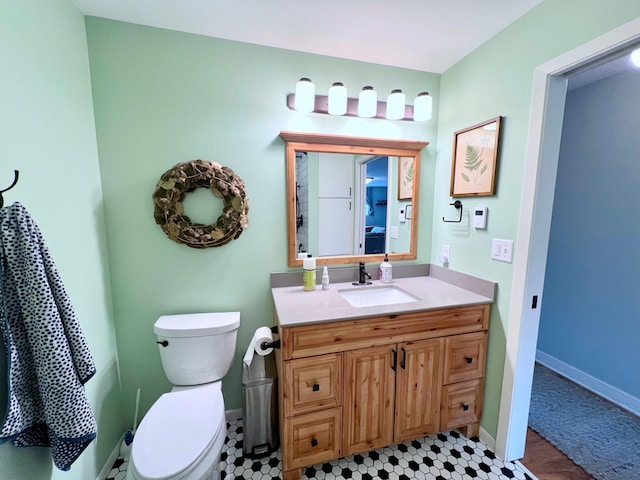 half bathroom with baseboards, toilet, and vanity