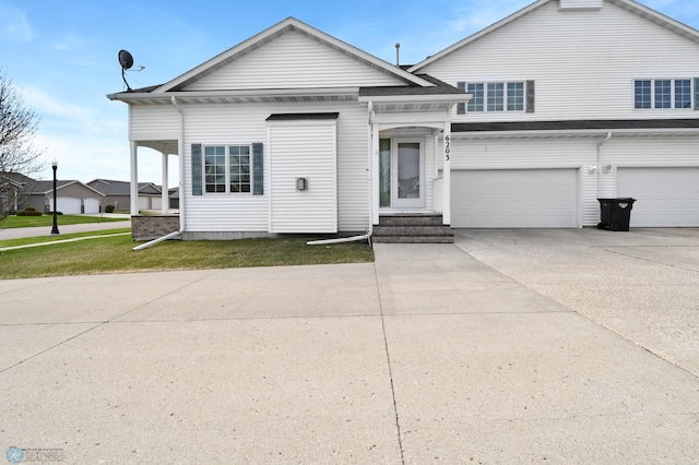 view of front of house featuring a garage, driveway, and a front yard