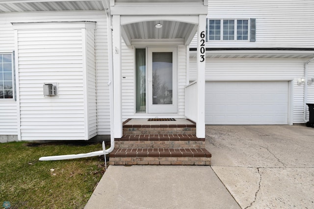 entrance to property featuring an attached garage and driveway