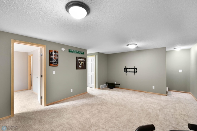 workout room with baseboards, a textured ceiling, and carpet