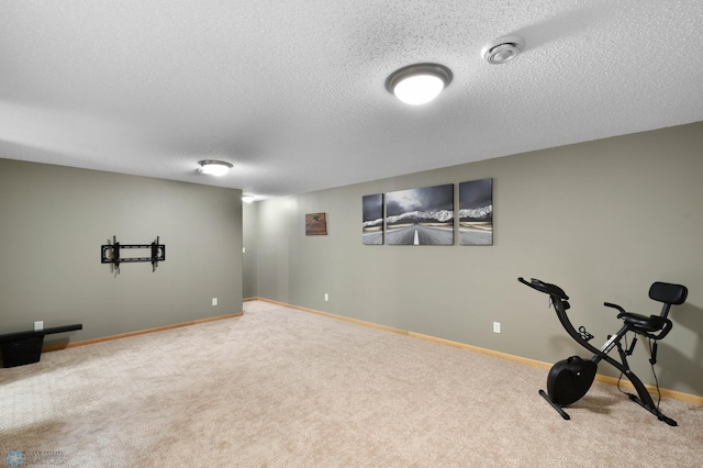 workout room featuring carpet floors, a textured ceiling, and baseboards