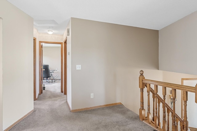 corridor featuring an upstairs landing, carpet, and baseboards