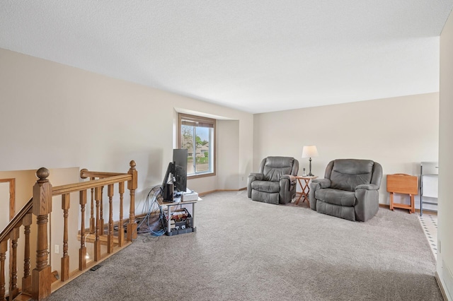 sitting room featuring carpet floors, an upstairs landing, and baseboards