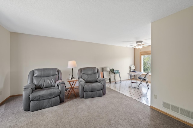living area with a ceiling fan, baseboards, and carpet