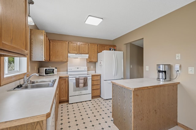 kitchen with white appliances, under cabinet range hood, a sink, light countertops, and light floors