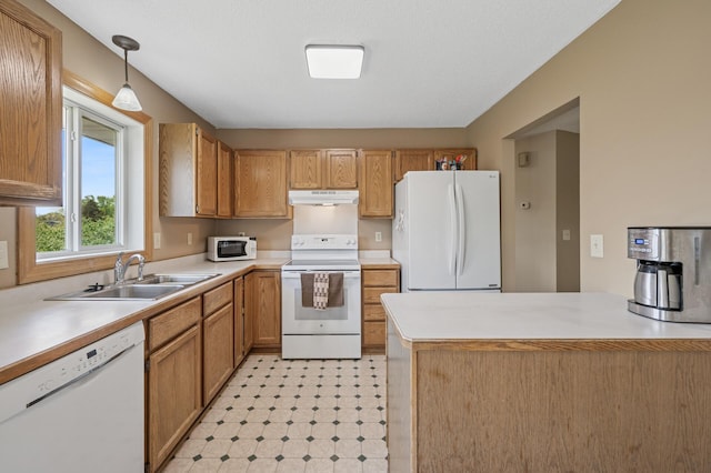 kitchen with white appliances, under cabinet range hood, a sink, light countertops, and pendant lighting