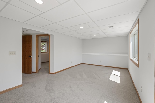 empty room with carpet floors, a paneled ceiling, recessed lighting, and baseboards