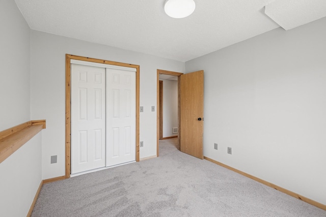 unfurnished bedroom with carpet floors, baseboards, and a closet