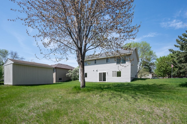 rear view of house with a lawn and an outbuilding