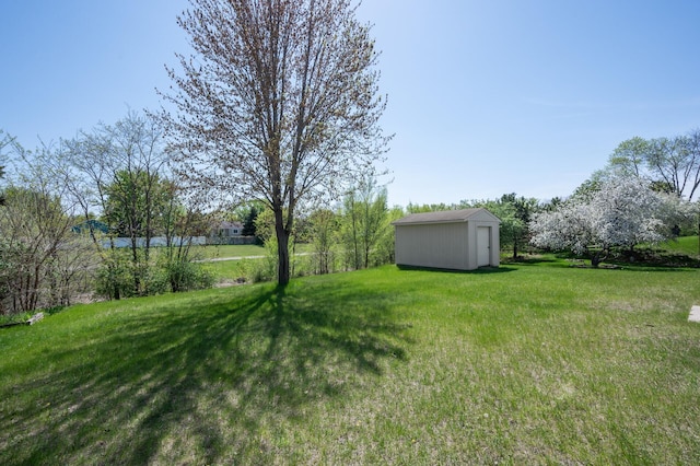 view of green lawn with a shed and an outbuilding