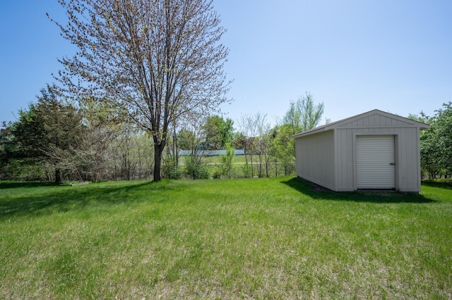 view of grassy yard with a storage unit and an outbuilding