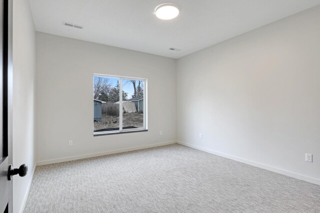 spare room featuring carpet, baseboards, and visible vents