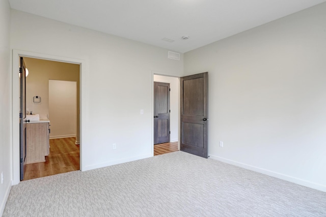 unfurnished bedroom with baseboards, carpet floors, and visible vents