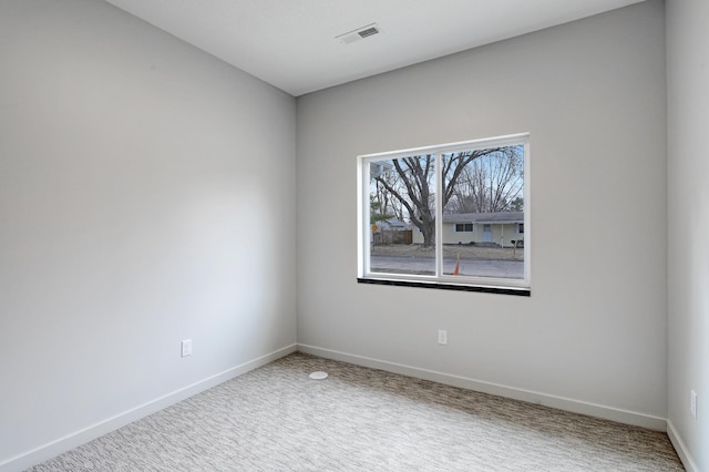 unfurnished room featuring baseboards, visible vents, and carpet floors