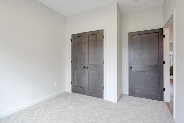 unfurnished bedroom with baseboards, a closet, and carpet