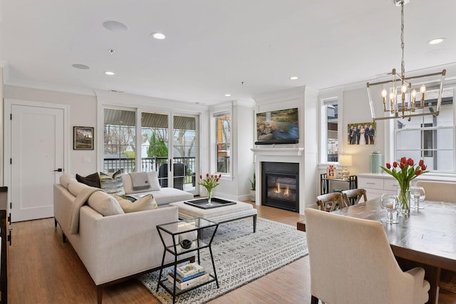 6112 Kellogg Unit 200D, Edina, MN 55424 - living area featuring a glass covered fireplace, crown molding, a chandelier, wood finished floors, and recessed lighting