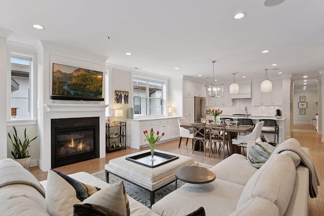 6112 Kellogg Unit 200D, Edina, MN 55424 - living room featuring recessed lighting, a glass covered fireplace, light wood-style floors, baseboards, and ornamental molding