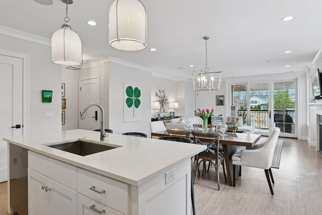 6112 Kellogg Unit 200D, Edina, MN 55424 - kitchen with a sink, ornamental molding, light wood-type flooring, a chandelier, and an island with sink