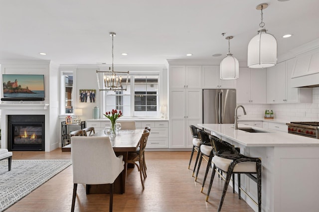 6112 Kellogg Unit 200D, Edina, MN 55424 - dining space featuring a chandelier, recessed lighting, a glass covered fireplace, and light wood-style floors