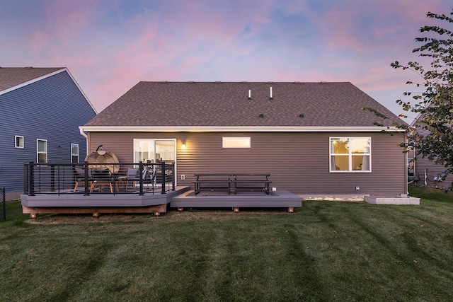 630 Stonegate Cir, Waconia, MN 55387 - back of property at dusk featuring a lawn, a deck, and roof with shingles
