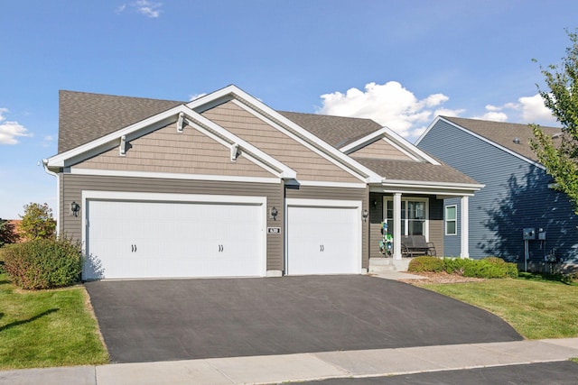 630 Stonegate Cir, Waconia, MN 55387 - view of front of home with asphalt driveway, a garage, roof with shingles, a porch, and a front lawn