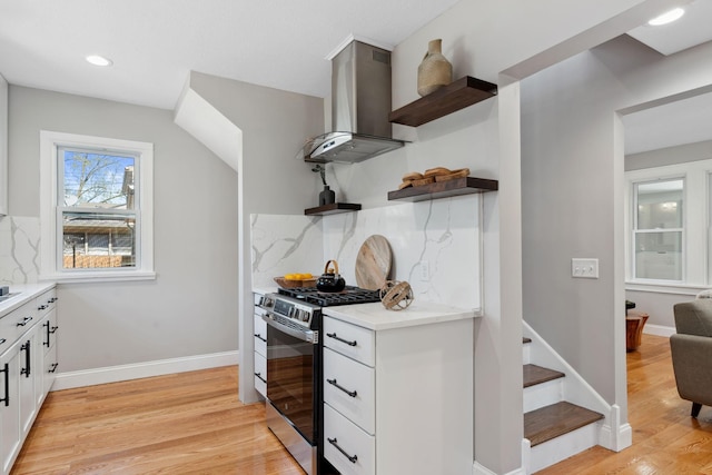 4015 Queen Ave N, Minneapolis, MN 55412 - kitchen featuring stainless steel range with gas stovetop, open shelves, wall chimney exhaust hood, light wood finished floors, and backsplash