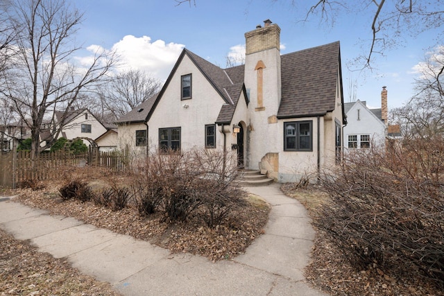 300 Diamond Lake Rd, Minneapolis, MN 55419 - view of front of house with roof with shingles, stucco siding, fence, and a chimney