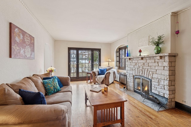 300 Diamond Lake Rd, Minneapolis, MN 55419 - living room with a textured wall, arched walkways, a stone fireplace, and wood finished floors