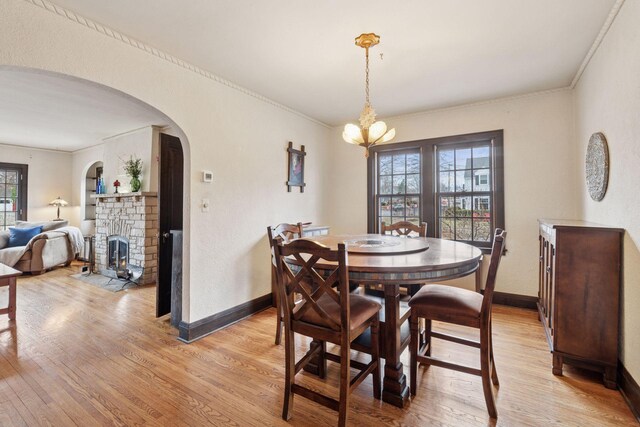 300 Diamond Lake Rd, Minneapolis, MN 55419 - dining area with a notable chandelier, baseboards, light wood-style flooring, crown molding, and arched walkways