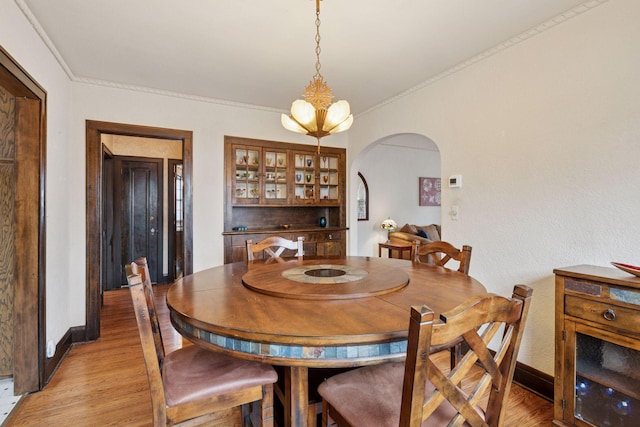 300 Diamond Lake Rd, Minneapolis, MN 55419 - dining room with crown molding, light wood-style flooring, arched walkways, and baseboards