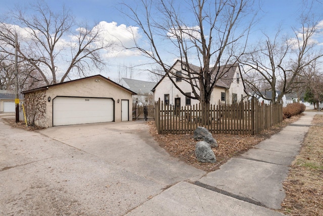 300 Diamond Lake Rd, Minneapolis, MN 55419 - view of front of house with stucco siding, a detached garage, an outbuilding, and a fenced front yard