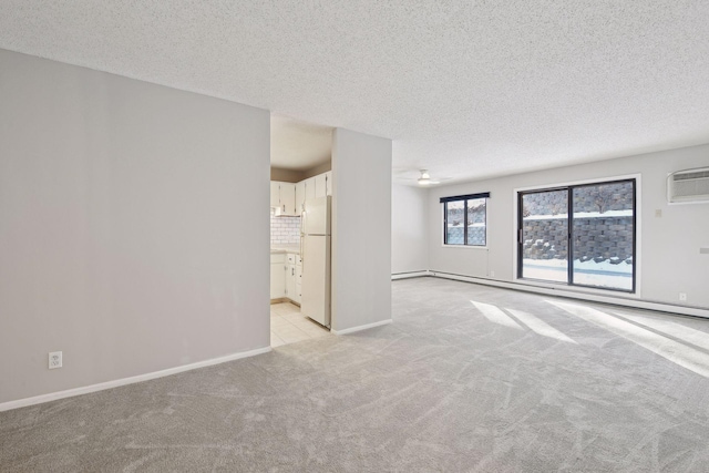 unfurnished living room with a textured ceiling, light colored carpet, a ceiling fan, a wall mounted air conditioner, and baseboards