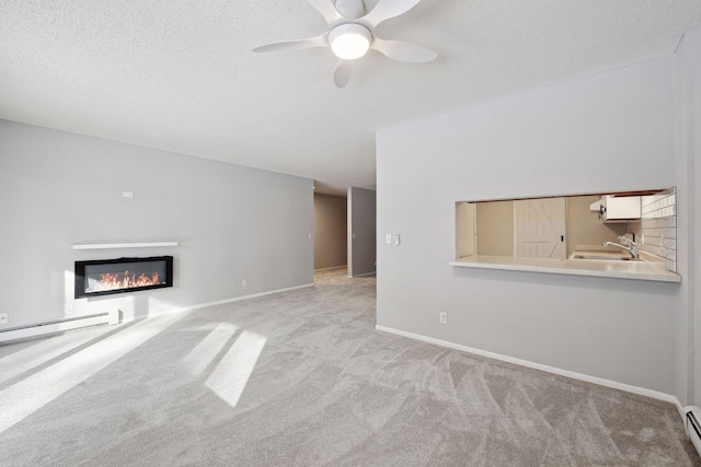 unfurnished living room with a baseboard radiator, a ceiling fan, carpet, and a textured ceiling